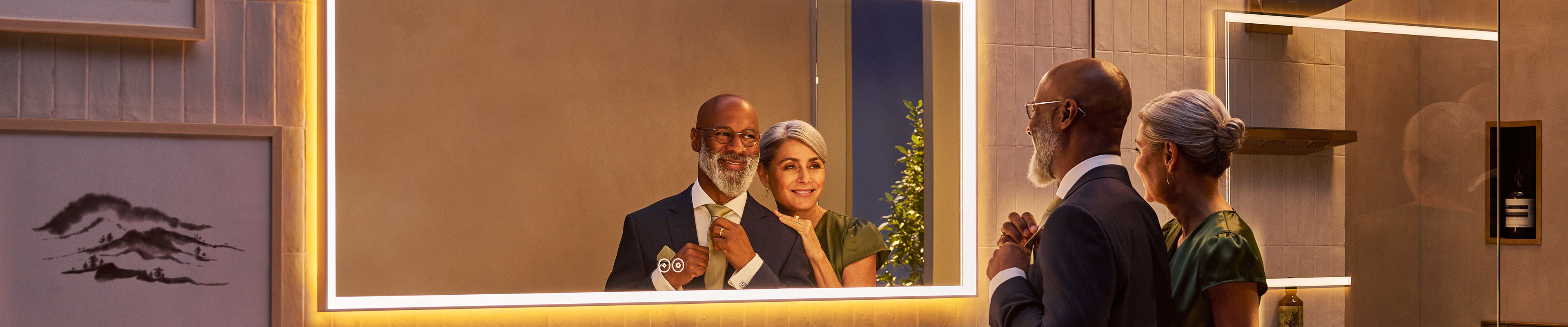Couple looking at themselves in an illuminated Xarita E mirror.