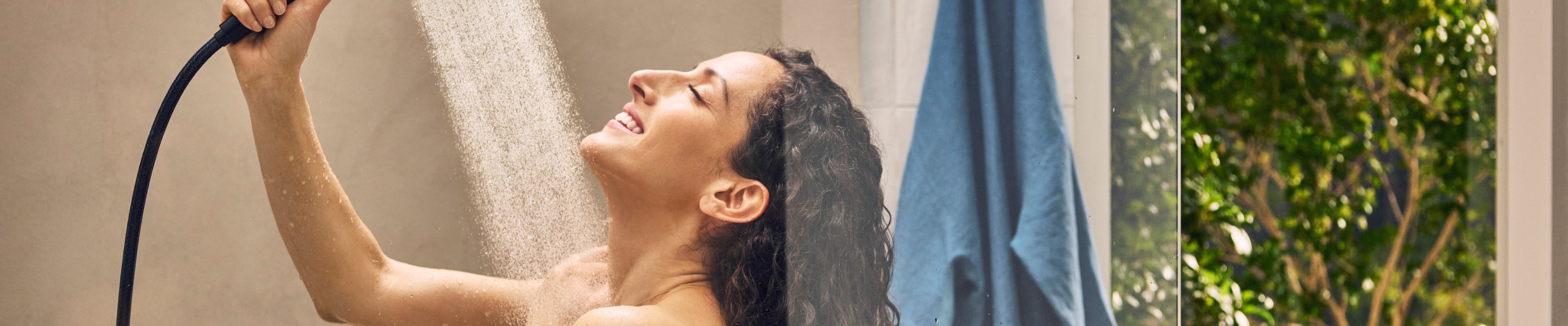 Woman showering with Rainfinity, Designflex shower hose.